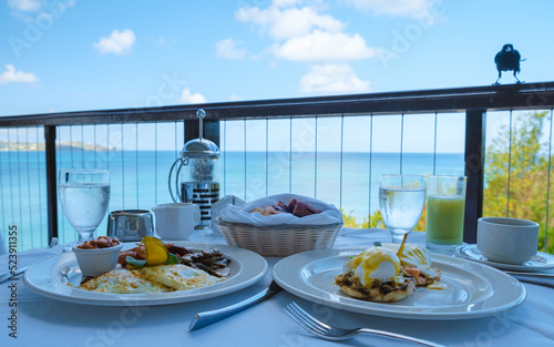 poached eggs with salmon breakfast, egg benedict with a look over the ocean of Saint Lucia Caribbean. men and women on a luxury vacation in St Lucia
