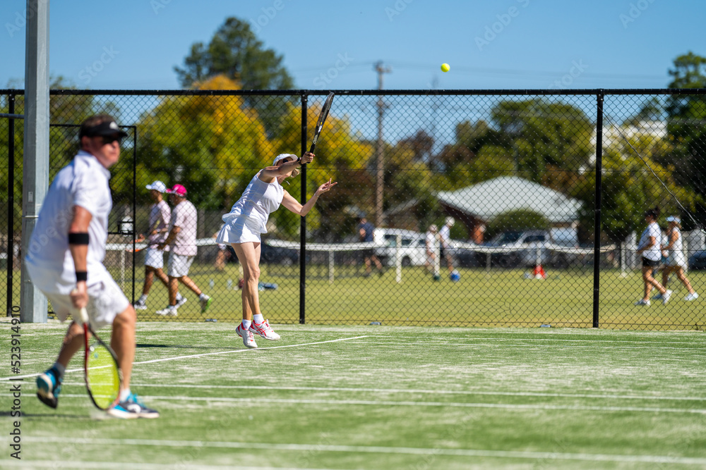 Tennis player hitting tennis balls in a tennis match on grass courts in a tournament 