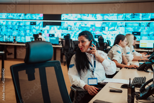 Fotografia Female security guard operator talking on the phone while working at workstation