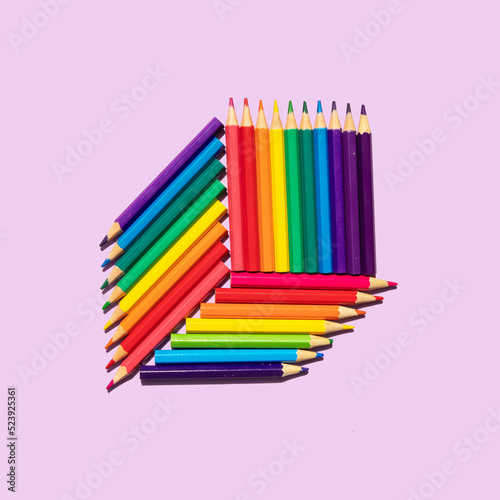 Minimal composition with colored pencils on pastel bright purple background. Back to school idea. Creative education concept. Creativity flat lay.