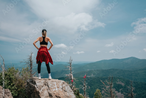 A girl on top of Falaza mountain looks at a beautiful mountain valley. Travel and tourism. Hiking photo