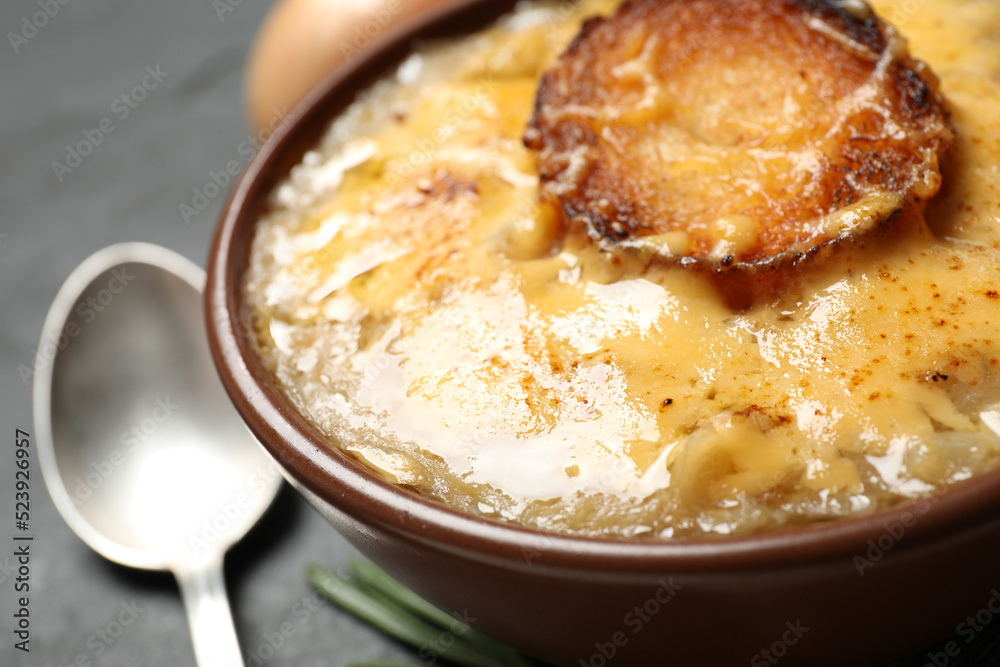 Tasty homemade french onion soup served in ceramic bowl, closeup