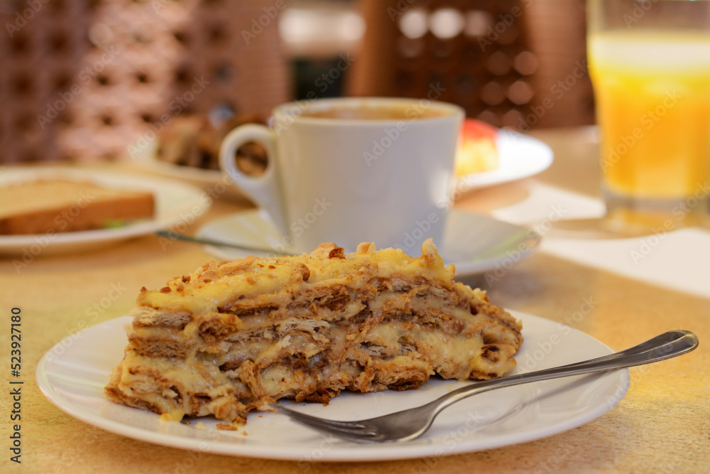 Piece of delicious cake and coffee on beige table in cafe, closeup Piece of delicious cake and coffee on beige table in cafe, closeup