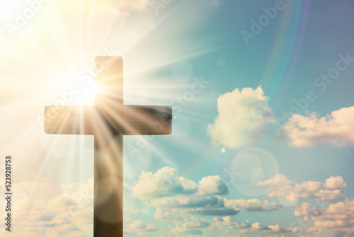 Silhouette of cross against blue sky on sunny day. Christian religion