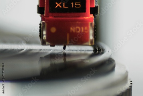 Closeup shot of a red phono cartridge with its needle on the turntable photo