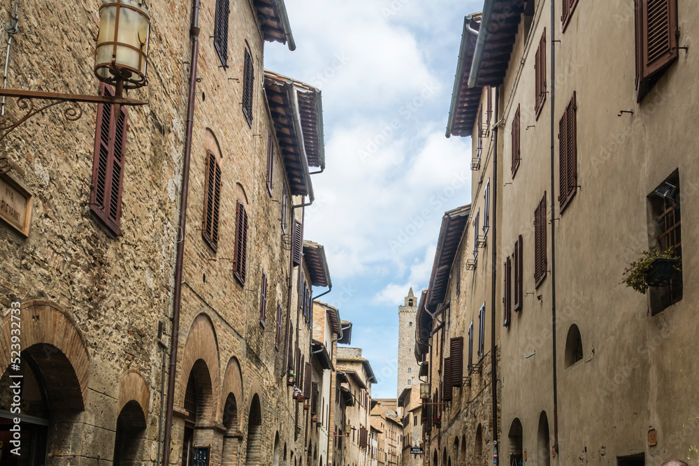 Narrow pedestrian street with medieval buildings at San Gemignano, Tuscany, Italy.