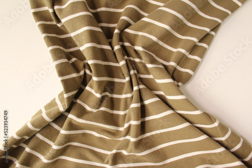 Green ocher crumpled fabric linen with white stripe for creative background. Copy space. Natural textile for wallpaper or design