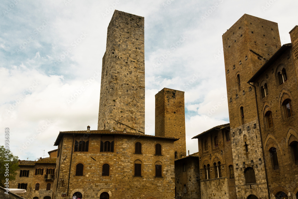 Three medieval tower and stone buildings against the sky at San Gemignano, Tuscany, Italy.