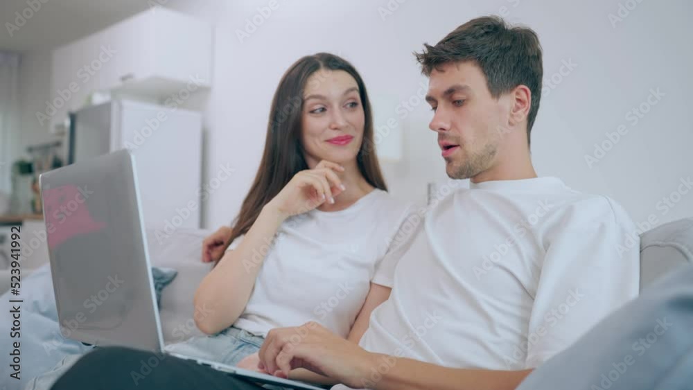 Caucasian young couple using laptop computer in living room at home. Caucasian young couple using laptop computer in living room at home.