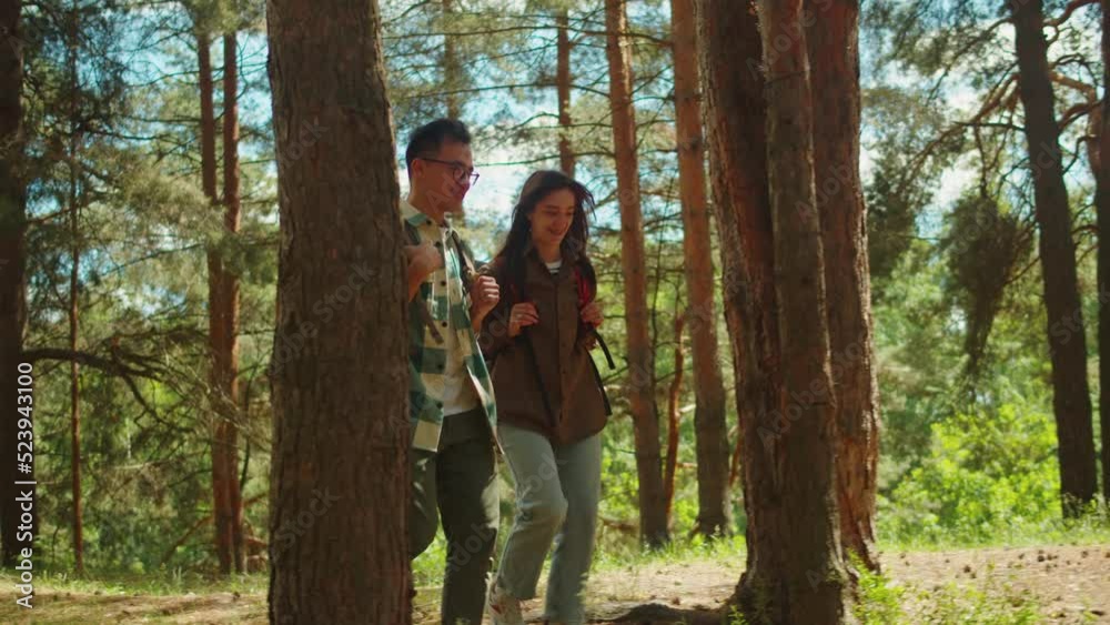 Young couple tourists walking in forest. Man and woman hikers traveling, students hiking together, wearing backpacks. Summer tourism, wild nature. Young couple tourists walking in forest. Man and woman hikers traveling, students hiking together, wearing backpacks. Summer tourism, wild nature.