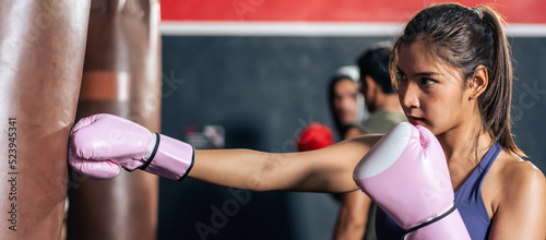 Group of athlete hitting a punching bag or sandbag at fitness gym club