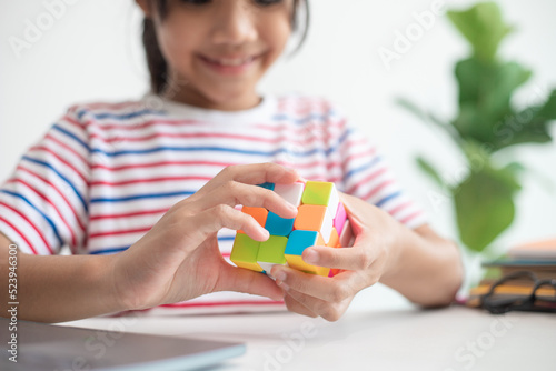 фотографія NAKHON RATCHASIMA, THAILAND - JULY 14, 2022:Asian little cute girl holding Rubik's cube in her hands