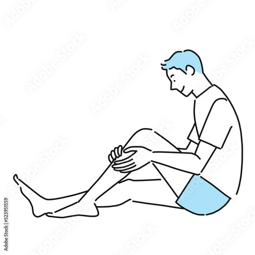 足のすねを触る若い男性
