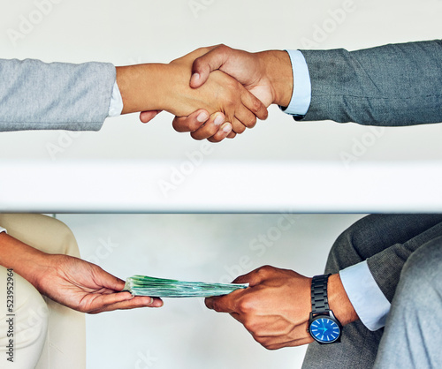 . Bribe, illegal deal and money laundering businessmen doing handshake agreement during corrupt business meeting or unethical exchange. Corporate man bribing or soliciting influence with cash. photo