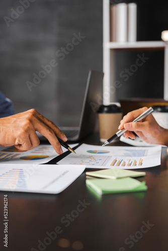 The financiers using calculator calculating personal taxes with colleagues in office workplace.