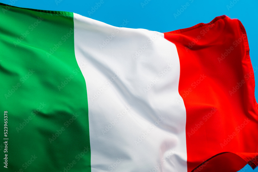 Italian flag waving on blue background