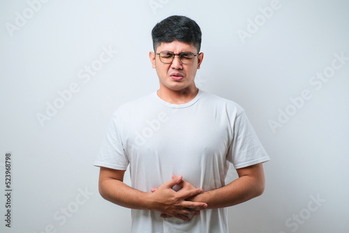 Asian young man getting stomach ache or getting abdominal pain health problem discomfort diarrhea
