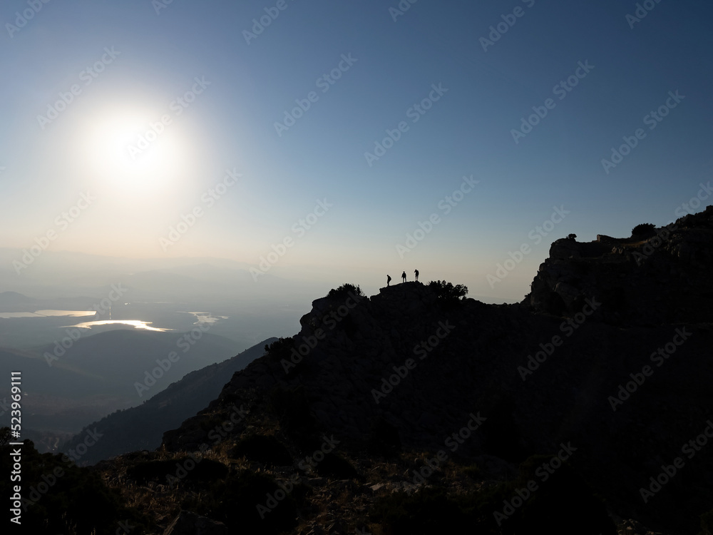 successful mountaineering team and small silhouettes in the majestic and high mountains