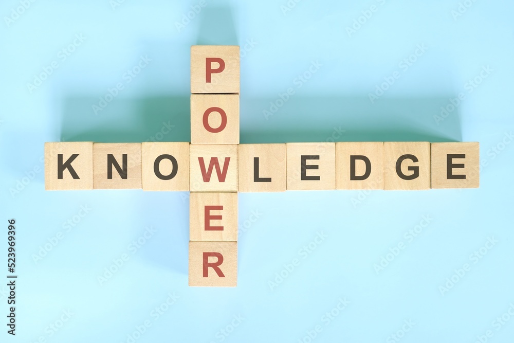 Knowledge is power concept. Wooden block crossword puzzle flat lay in blue background. Knowledge is power concept. Wooden block crossword puzzle flat lay in blue background.