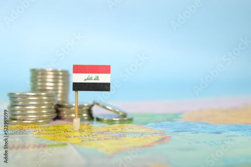 фотографія Selective focus of Iraqi flag in blurry world map with coins