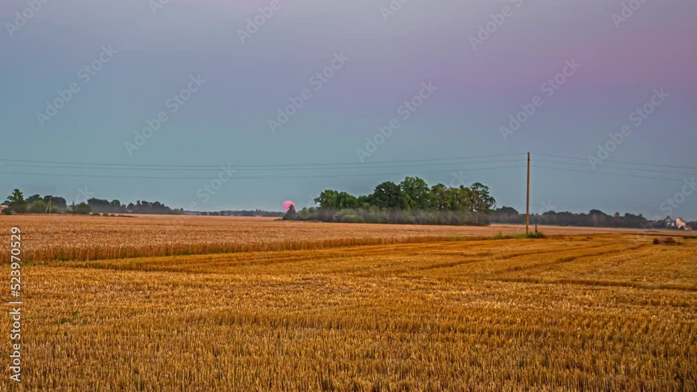 A super moon rises over rural farmland at twilight - time lapse A super moon rises over rural farmland at twilight - time lapse