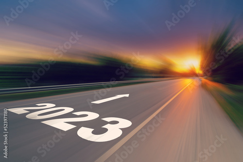 Motion blur empty asphalt road and New year 2023 concept. Driving on an empty road to Goals 2023 with sunset.