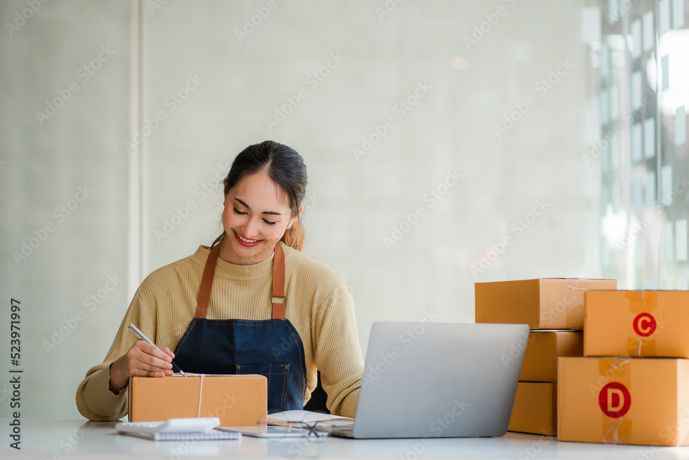 Small business startups, SME owners, Asian women entrepreneurs Successfully working with boxes and checking online orders with a laptop to prepare. Sell to customers. Online SME Business Ideas Small business startups, SME owners, Asian women entrepreneurs Successfully working with boxes and checking online orders with a laptop to prepare. Sell to customers. Online SME Business Ideas