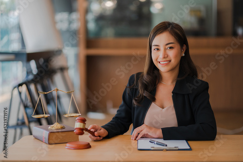 Lawyer's Office. An Asian goddess of justice with scales and an Asian female lawyer holding a hammer working in law firms, advice and justice concepts.