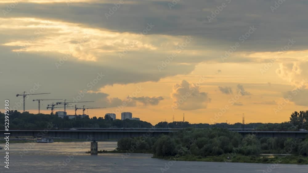 Timelapse with cranes on the construction site under the fast moving clouds during the sunset Timelapse with cranes on the construction site under the fast moving clouds during the sunset