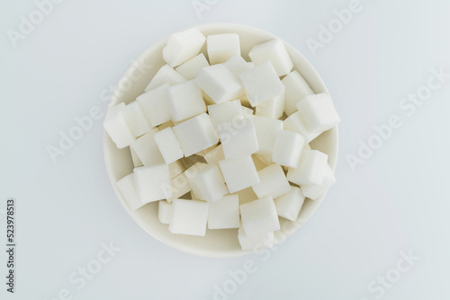 Sugar cubes on a plate on white background