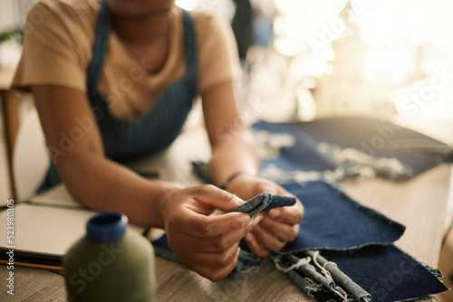 Fashion design student sewing, learning and making creative denim clothes in a clothing manufacturing factory. Industry, artistic and fashionable designer busy in a workshop working on stylish jeans