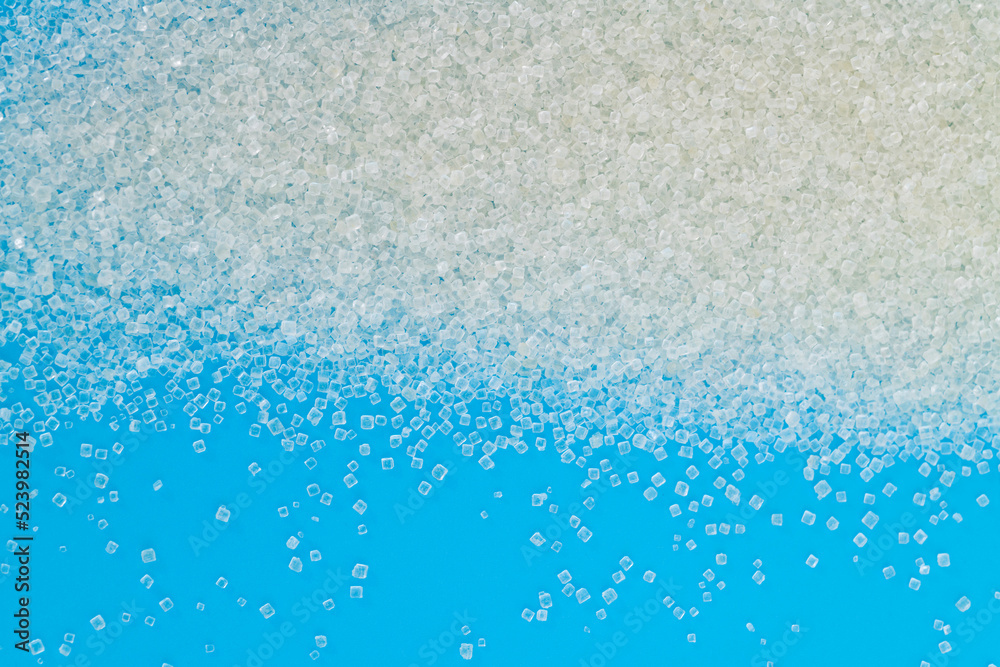 Fototapeta premium White sugar crystals on blue background