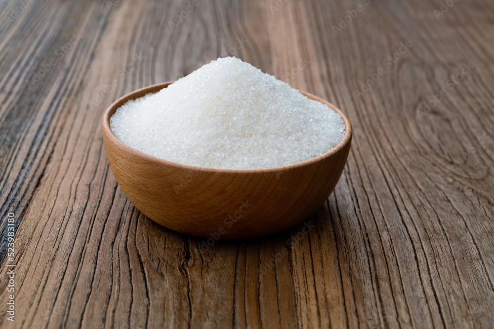 Granulated sugar in a bowl on wooden table Granulated sugar in a bowl on wooden table