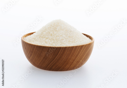 Granulated sugar in a bowl on white background