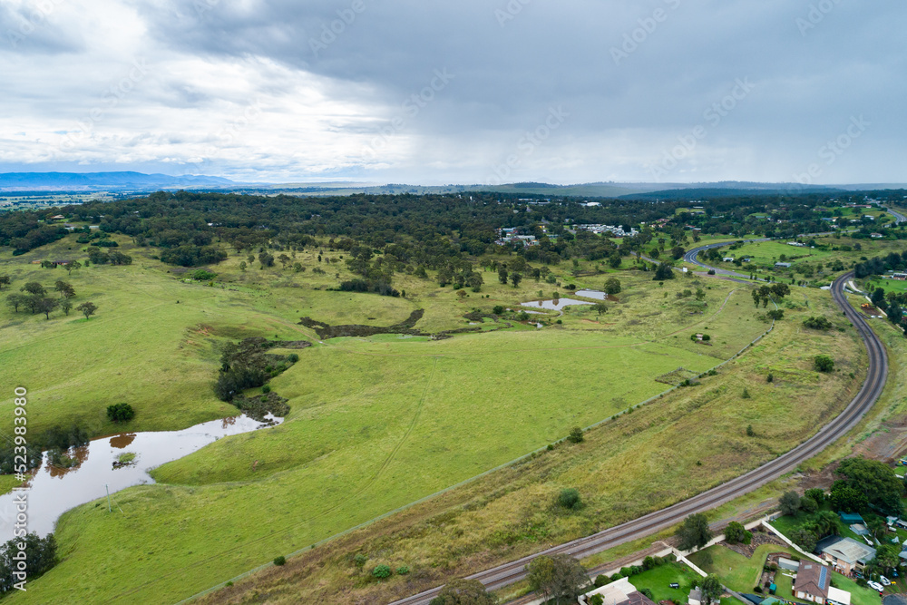 Rain incoming over green farmland and railway track Rain incoming over green farmland and railway track