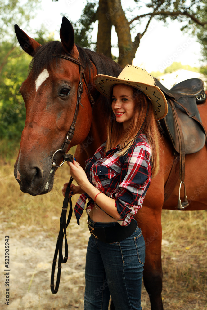 Obraz premium Young woman in hat with horse