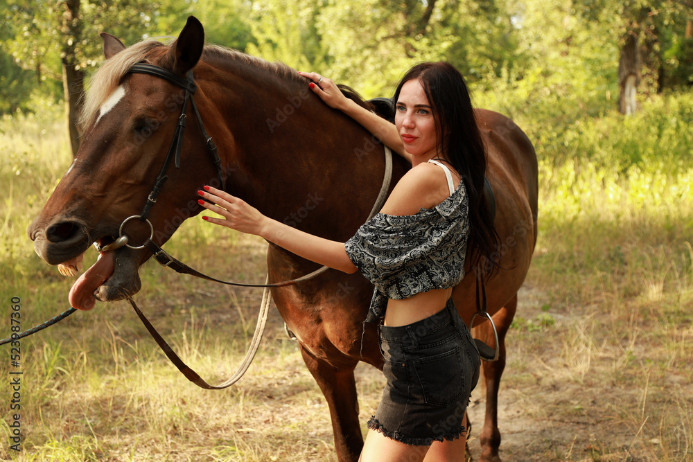 Fototapeta premium Young woman with a horse in the park