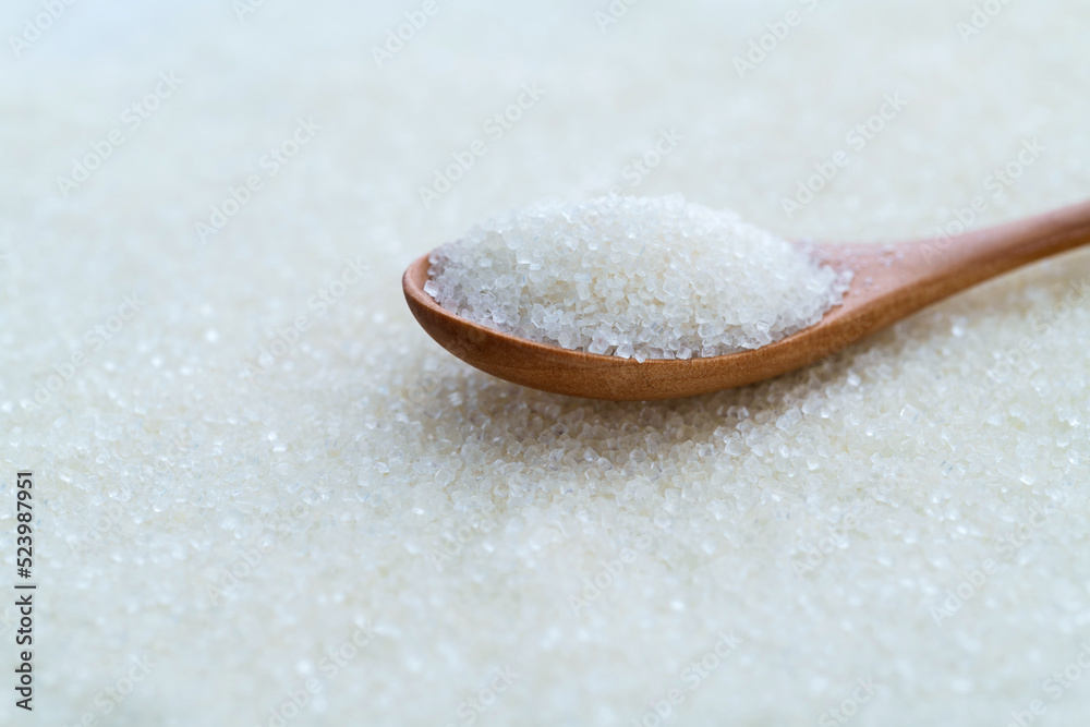 Granulated sugar on wooden spoon Granulated sugar on wooden spoon