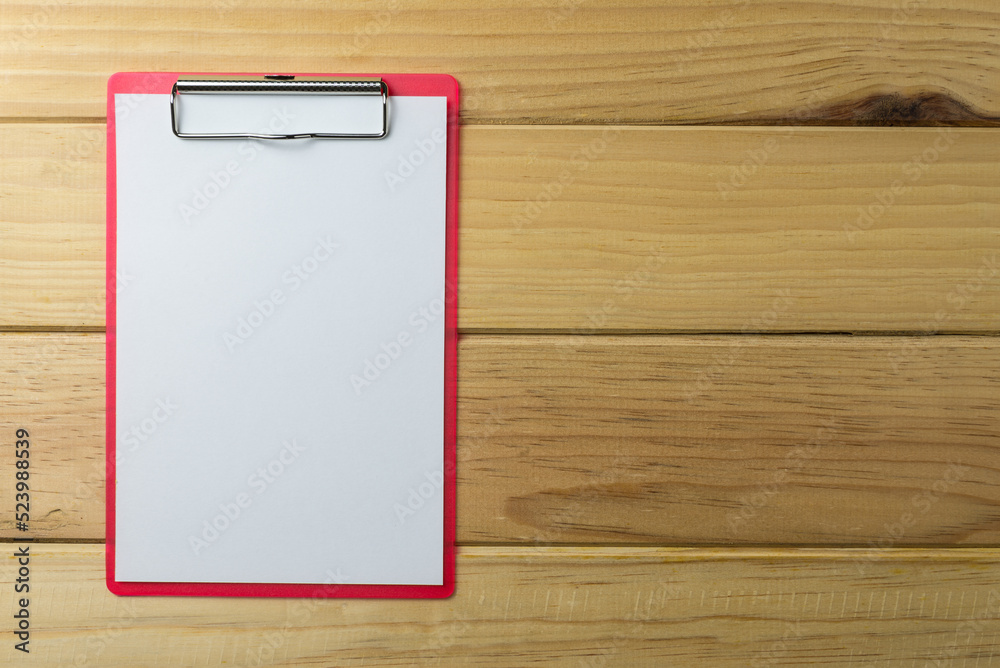 Blank red clipboard with paper on wood background copy space. Business, office supply, stationery concept. Blank red clipboard with paper on wood background copy space. Business, office supply, stationery concept.