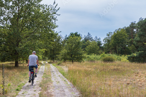 Tourist cycling along the green belt near Domitz former inner-German border and death strip between East and West Germany during the cold war. Nowadays a major biosphere park in Germany. © HildaWeges