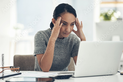 Confused, stressed and anxious businesswoman with laptop suffering from a headache, pressure and agency deadline. Creative entrepreneur thinking of solution, making mistake and trying to understand photo