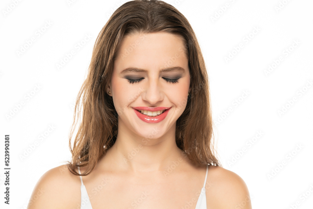 Beautiful smiling woman with make up and closed eyes on a white background. Beautiful smiling woman with make up and closed eyes on a white background.