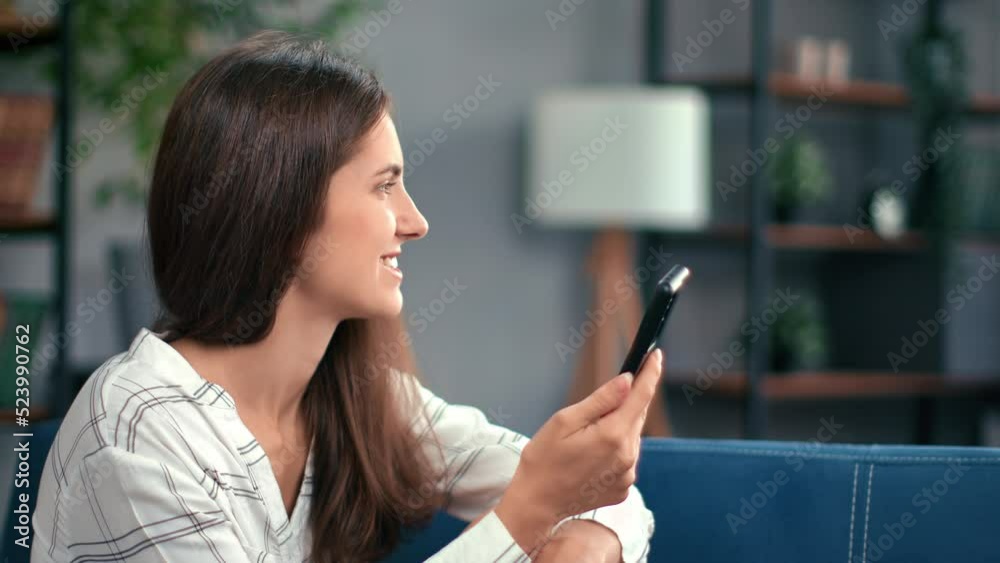 Cute modern female chatting smartphone social networks online dating application at comfy home couch Cute modern female chatting smartphone social networks online dating application at comfy home couch
