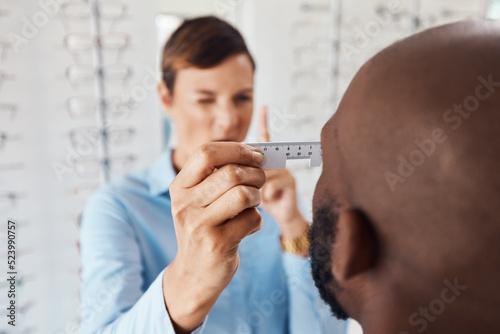 Optometrist, doctor and specialist checking vision retina measurement and sight of a patient with optical PD ruler during eye test in a clinic. Eye doctor giving treatment for prescription glasses photo