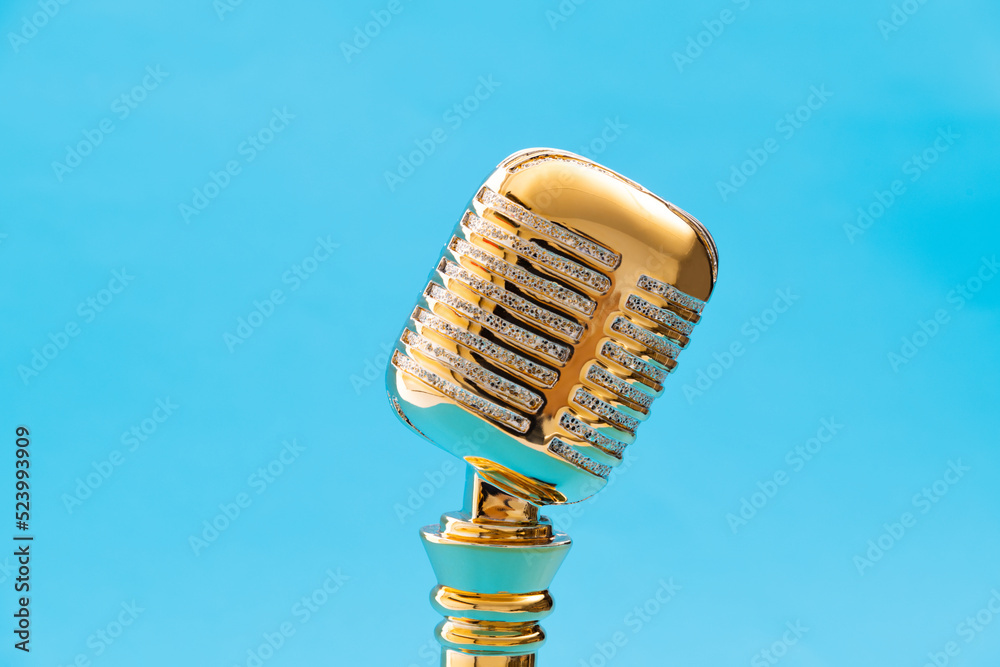 Golden microphone trophy on blue background Stock Photo | Adobe Stock