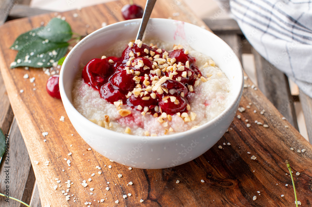 Millet breakfast porridge with cherry compote and roasted nuts Millet breakfast porridge with cherry compote and roasted nuts