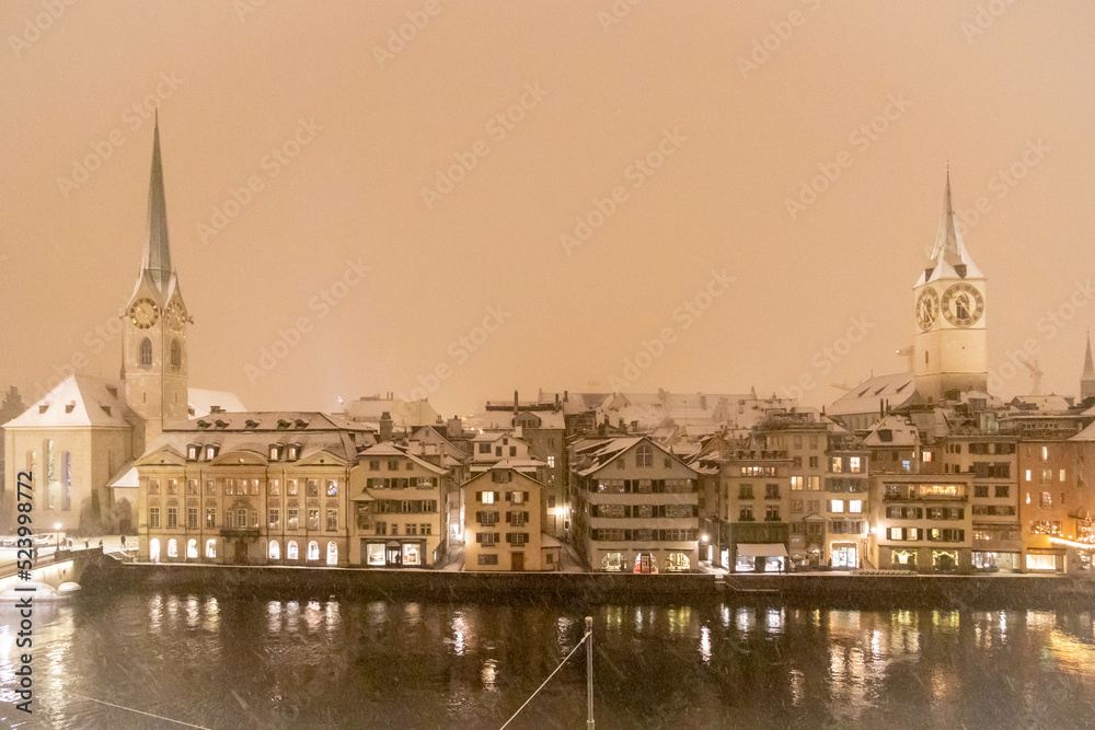 Altstadt in Zürich über der Limmat, Schnee und Sturm, die Kirchen St. Peter und Fraumünster im Spiegel des Wassers