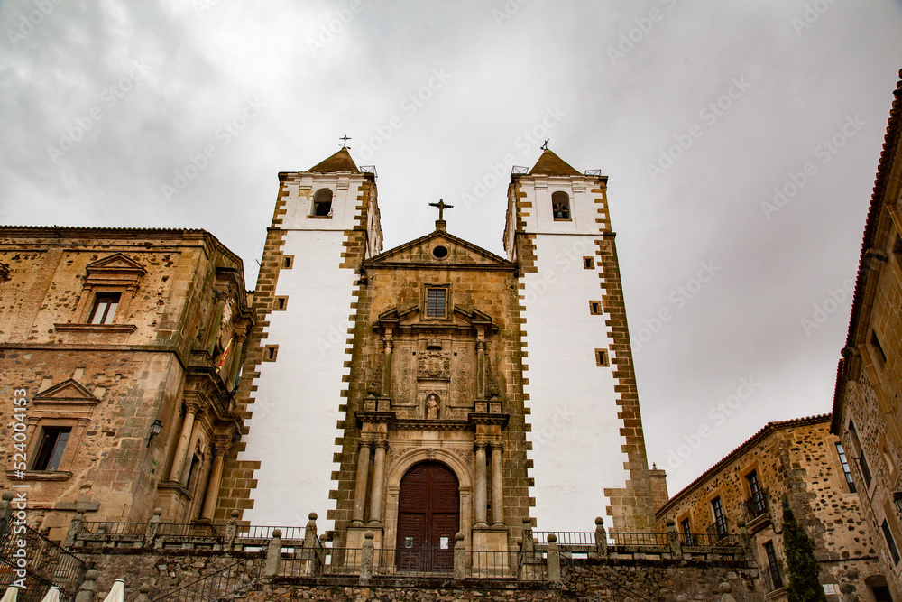 Iglesia con fachada de piedra y torres blancas sobre escaleras de piedra
