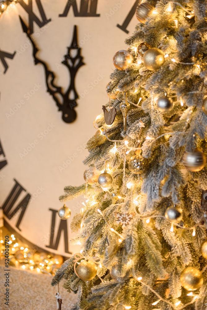 Christmas Tree with Garland, Golden Toys on Vertical Photo. Big Clock in Background Shows Midnight