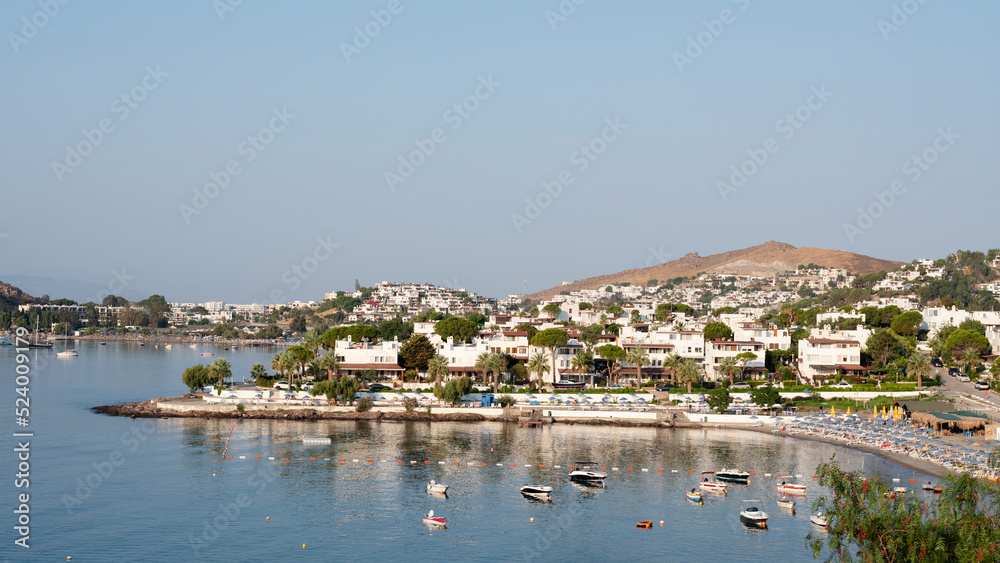 View of Bodrum Beach, Aegean sea, traditional white houses, flowers, marina, sailing boats, yachts in Bodrum town Turkey. Front view